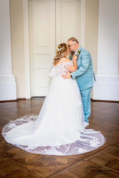 Braut und Bräutigam umarmen sich romantisch in eleganter Hochzeitskleidung.