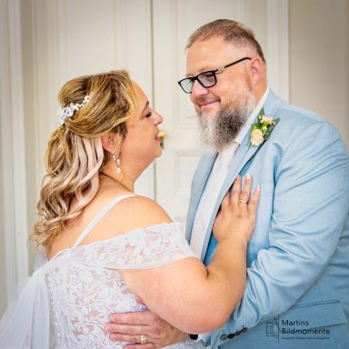 Braut und Bräutigam lächeln sich glücklich an, umgeben von romantischer Atmosphäre.